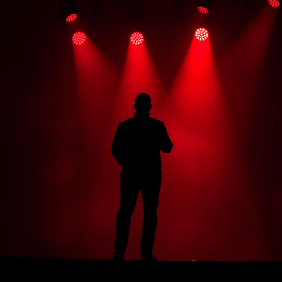 Speaker on stage under red lighting