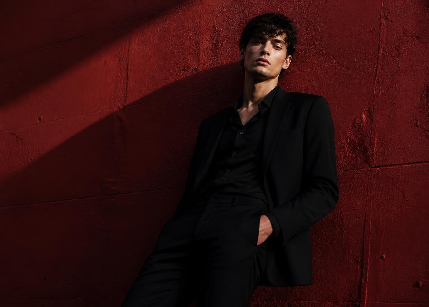 Editorial portrait against a deep red wall